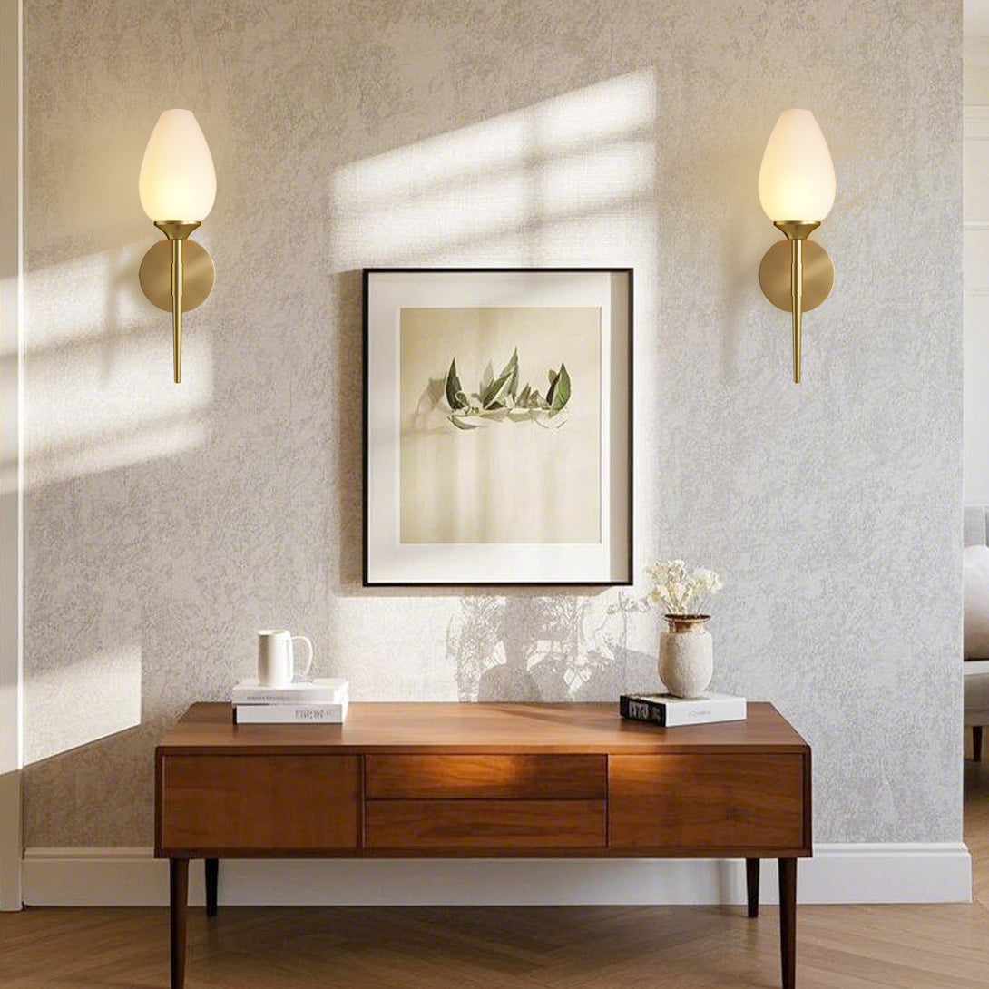 Pair of frosted glass wall sconces flanking artwork above a console