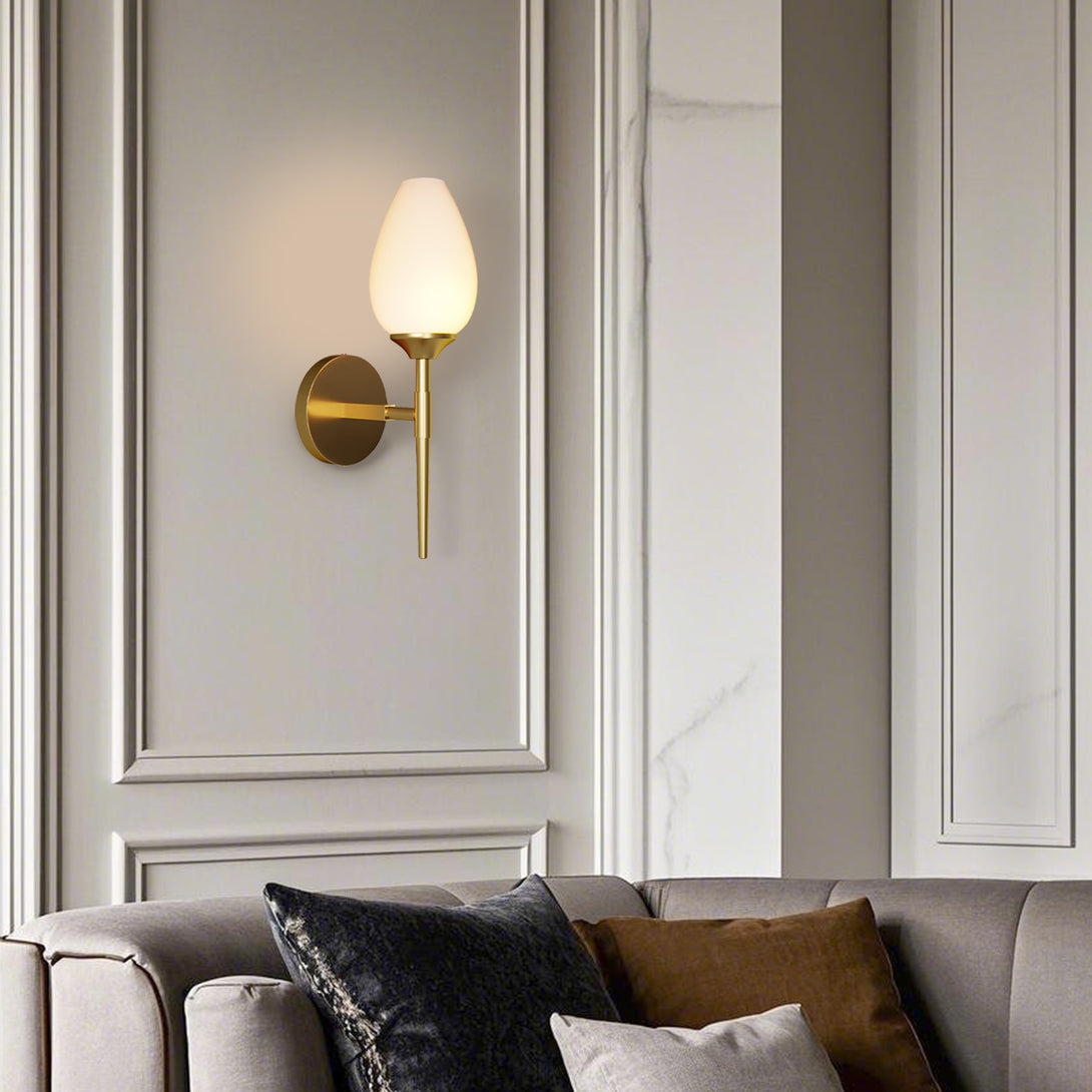 Single frosted glass wall sconce above a pale sofa in a daylight interior